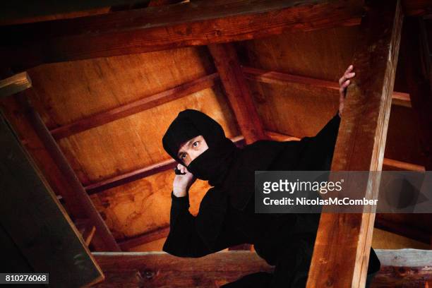 japanese ninja in black costume hiding wooden attic ready to attack - ninja stock pictures, royalty-free photos & images