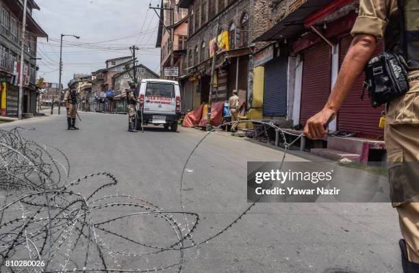 Indian paramilitary troopers stand alert during a curfew ahead of the first death anniversary of Burhan Wani a young rebel commander, on July 7, 2017...