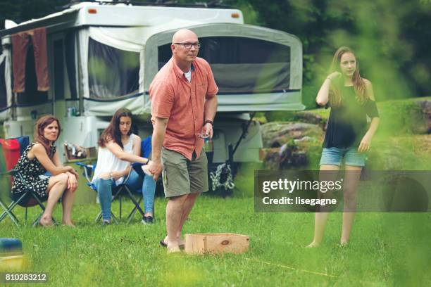 familie spelen van een spel in de buitenlucht - camping games stockfoto's en -beelden