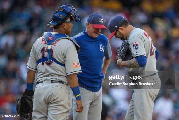 Catcher Salvador Perez of the Kansas City Royals, pitching coach Dave Eiland and relief pitcher Peter Moylan of the Kansas City Royals meet at the...