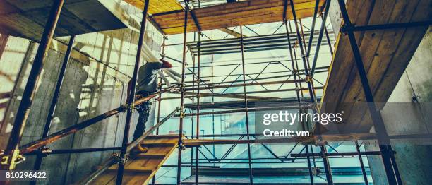 bau arbeiter auf den gerüsten - baustelle gerüst sonne stock-fotos und bilder