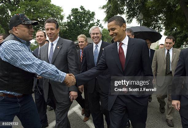 Democratic presidential hopeful Sen. Barack Obama, D-Ill., shakes hands with a tourist as he walks to the U.S. Capitol with House superdelegates...