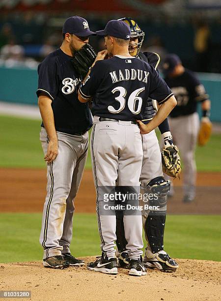 Starting pitcher Carlos Villanueva of the Milwaukee Brewers talks with catcher Mike Rivera and pitching coach Mike Maddux during action against the...
