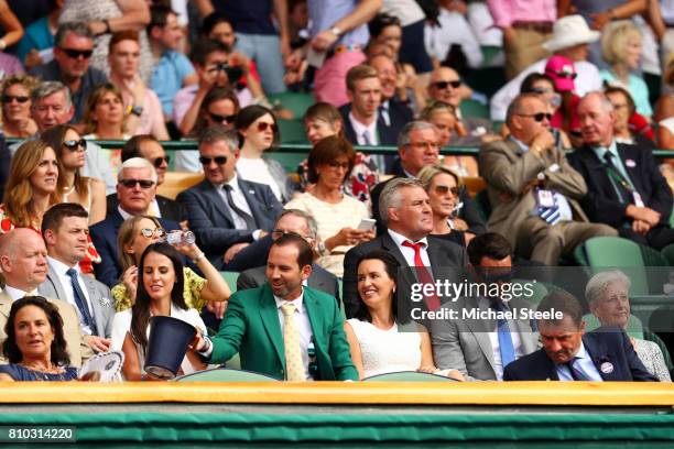 Golfer Sergio Garcia, his fiancee Angela Akins, Dan Carter and wife Honor Carter look on from the centre court royal box on day five of the Wimbledon...