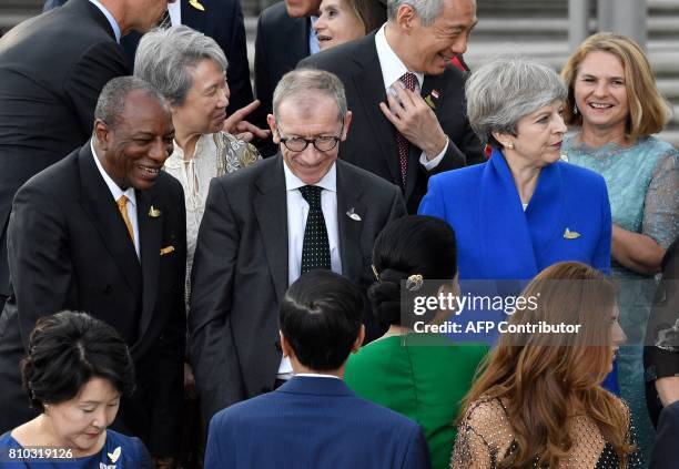 Britain's Prime Minister Theresa May and her husband the husband of Britain's Prime Minister Philip John May pose with other Participants of the the...