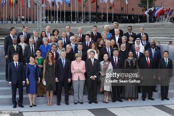 Leaders and their spouses pose for a group photo outside the Elbphilharmonie philharmonic concert hall on the first day of the G20 economic summit on...