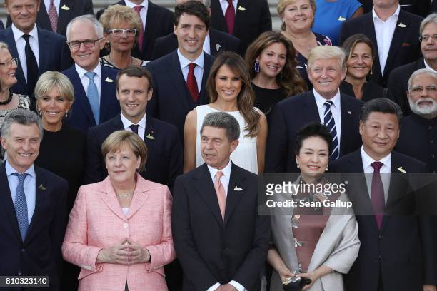 Leaders and their spouses, including U.S. President Donald Trump and First Lady Melania, French President Emmanuel Macron and his wife Brigitte...