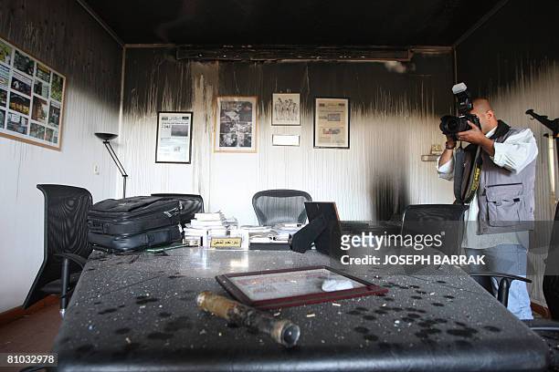 Photographer takes pictures of a damaged office in the Future movement's Al-Mustaqbal newspaper building after fire swept over one of its floors...