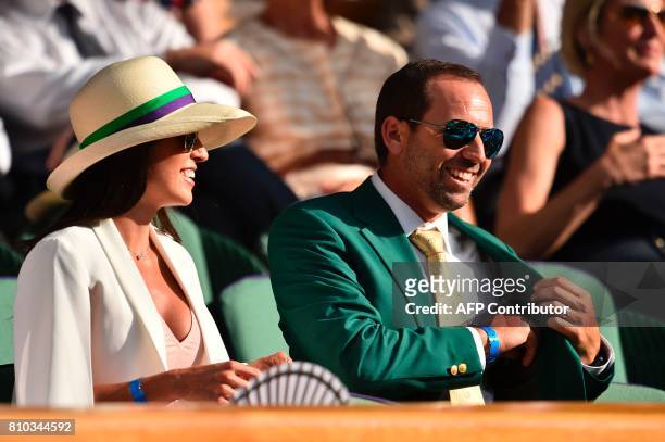Spanish golfer Sergio Garcia wearing his Masters jacket is seen sitting with his partner Angela Akins in the Royal Box on Centre Court on the fifth...