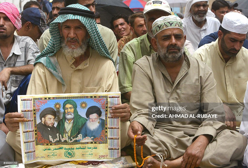 A Shiite Muslim man holds a poster with