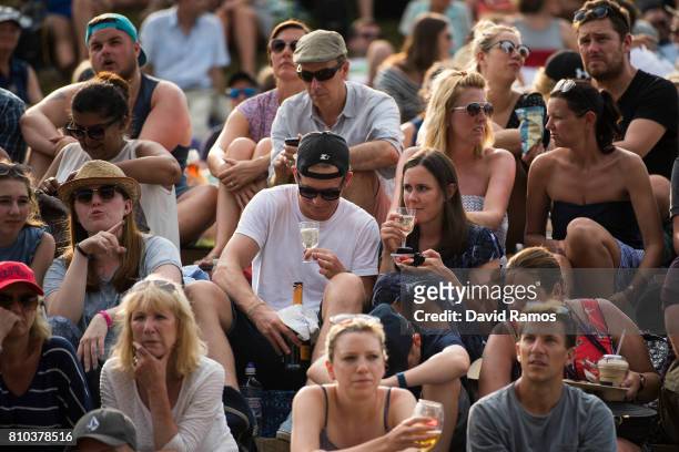 Spectators have Champagne, strawberries and cream on 'Murray Mound' on day five of the Wimbledon Lawn Tennis Championships at the All England Lawn...
