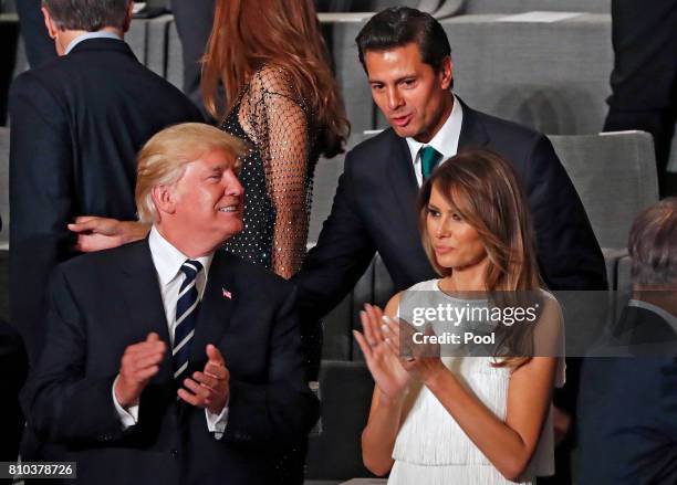 Mexican President Enrique Pena Nieto talks to US President Donald Trump and his wife Melania Trump as they attend a concert at the Elbphilharmonie...