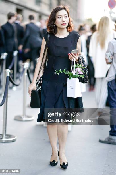 Guest wears a black dress and black heels shoes, outside the 'Christian Dior, couturier du reve' Exhibition Launch celebrating 70 years of creation...