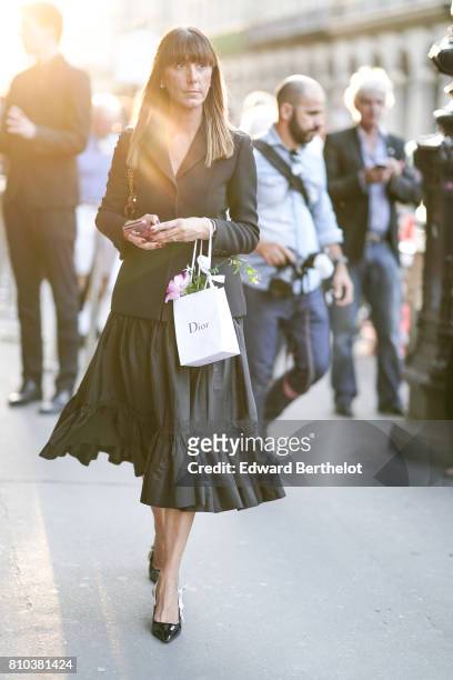 Guest wears a black blazer jacket, a black ruffled skirt, black heels shoes, outside the 'Christian Dior, couturier du reve' Exhibition Launch...