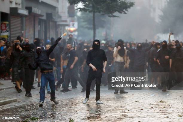 Protesters throw bottles at riot police on July 7, 2017 in Hamburg, northern Germany, where leaders of the world's top economies gather for a G20...