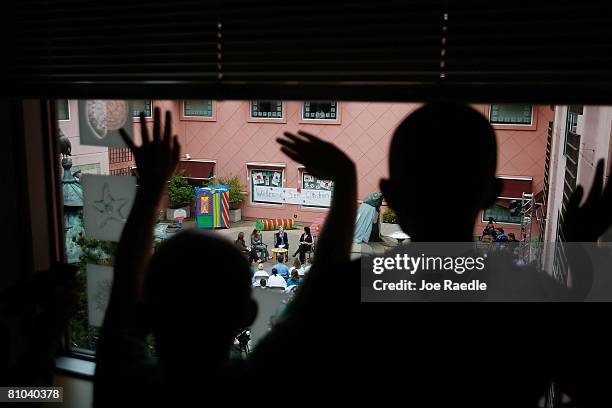 Children wave as Democratic presidential hopeful U.S. Senator Hillary Clinton sits with Jeannie Roberts, Jordan Kokich and Bridget Sheffler as she...