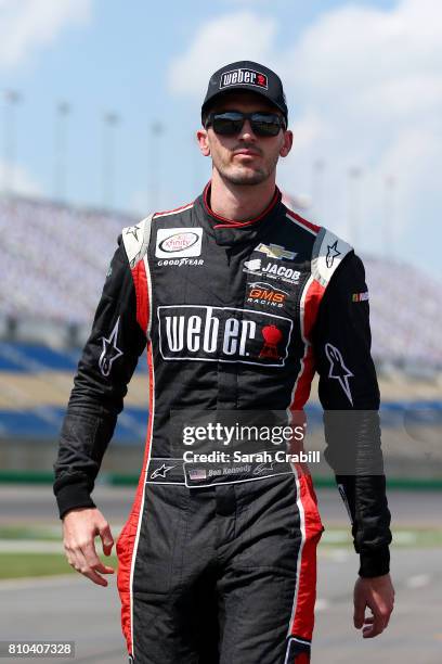 Ben Kennedy, driver of the Weber Chevrolet, walks to his car during qualifying for the NASCAR XFINITY Series Alsco 300 at Kentucky Speedway on July...