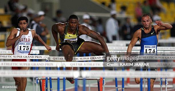 Olympics track and field team member David Oliver takes a hurdle next to Qatari Issa Mohammed and Britain's Andy Turner of during the men's 110 meter...