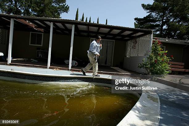 Contra Costa County Mosquito and Vector Control District technician Josefa Cabada turns the water in a neglected pool at a foreclosed home May 9,...