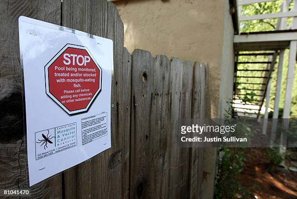 Sign is posted on a fence after Contra Costa County Mosquito and Vector Control District technician Josefa Cabada treated a neglected pool at a...