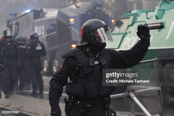 German riot policeman shows a tear gas spray during clashes on July 7, 2017 in Hamburg, Germany. Authorities are braced for large-scale and...