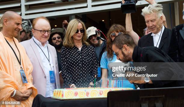 Recording artist Ringo Starr blows candles as wife Barbara Bach and director David Lynch, friends and family look on during Ringo Starr's birthday...