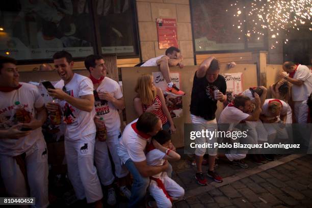Revellers take cover as the Toro del Fuego is run through the streets of Pamplona during the second day of the San Fermin Running of the Bulls...