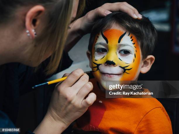 toddler getting face paint - kids makeup face stock-fotos und bilder