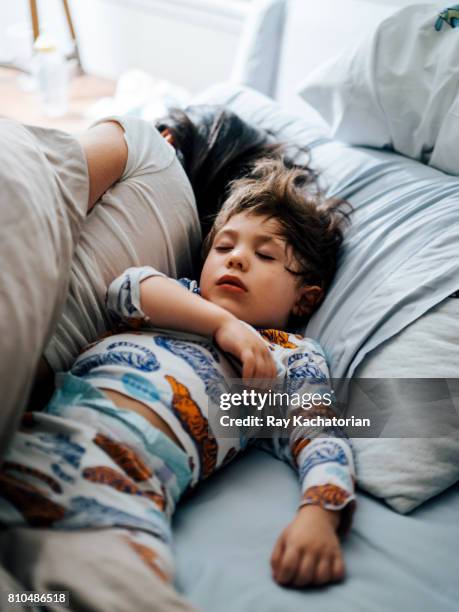 child asleep next to mother - boy asleep in bed stock pictures, royalty-free photos & images