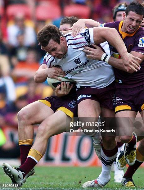 Josh Perry of the Sea Eagles attempts to push through the Broncos defence during the round 9 NRL match between the Brisbane Broncos and the Manly Sea...