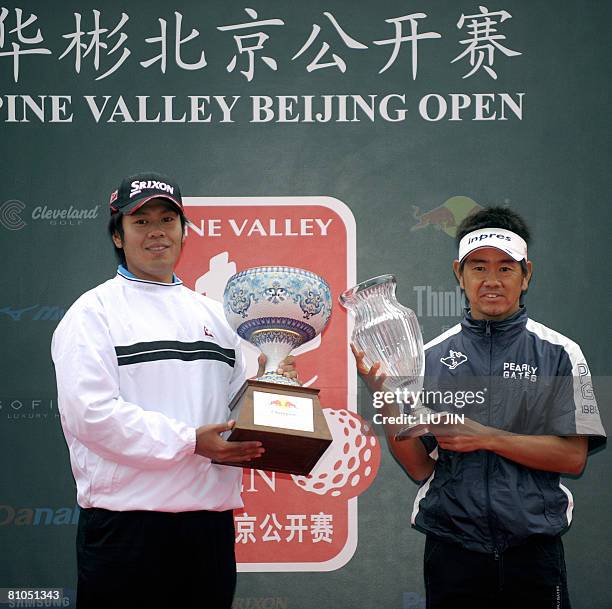 Japanese golfer Hiroyuki Fujita and his compatriot Shintaro Kai pose for photographs with their trophies at an awarding ceremny of the Pine Valley...