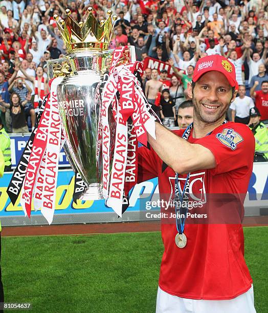 Ryan Giggs of Manchester United celebrates with the Premier League trophy on the pitch after the Barclays FA Premier League match between Wigan...