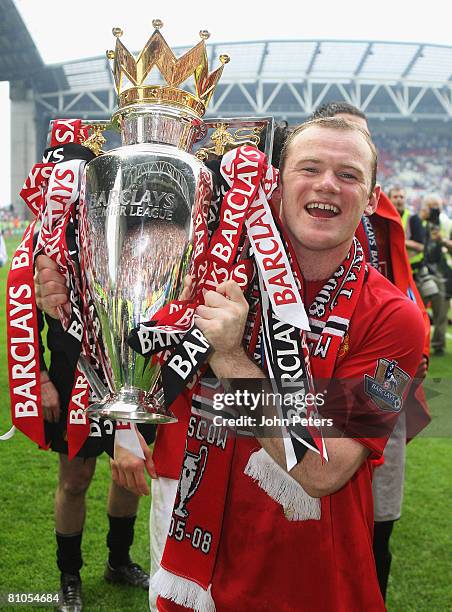 Wayne Rooney of Manchester United celebrates with the Premier League trophy on the pitch after the Barclays FA Premier League match between Wigan...