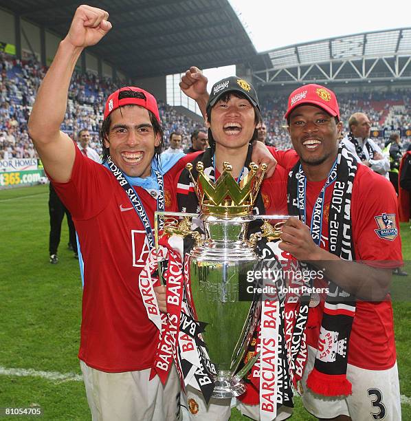 Carlos Tevez, Ji-Sung Park and Patrice Evra of Manchester United celebrates with the Premier League trophy on the pitch after the Barclays FA Premier...