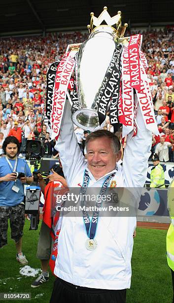 Sir Alex Ferguson of Manchester United celebrates with the Premier League trophy on the pitch the Barclays FA Premier League match between Wigan...