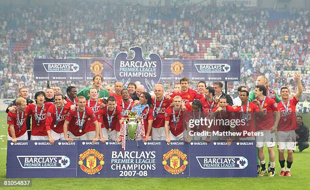 The Manchester United squad celebrate on the pitch with the Premiership trophy after the Barclays FA Premier League match between Wigan Athletic and...