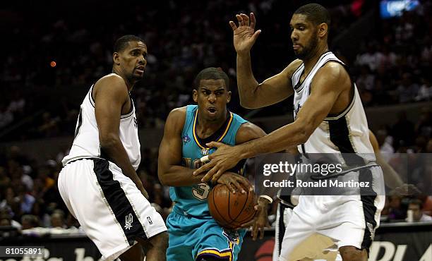 Guard Chris Paul of the New Orleans Hornets drives the ball against Kurt Thomas and Tim Duncan of the San Antonio Spurs in Game Four of the Western...
