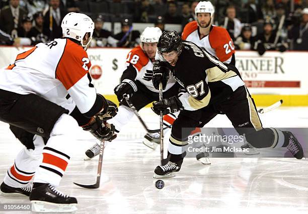 Sidney Crosby of the Pittsburgh Penguins controls the puck through Mike Richards and Derian Hatcher of the Philadelphia Flyers during game two of the...