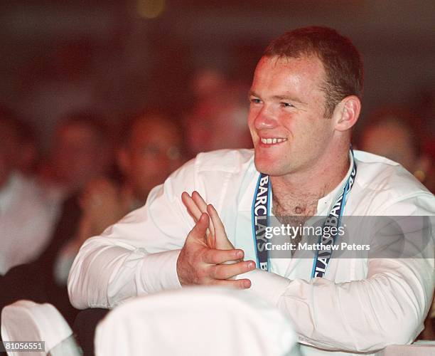 Wayne Rooney of Manchester United applauds Cristiano Ronaldo receiving his Players' Player of the Year award and the FA Premier League trophy during...