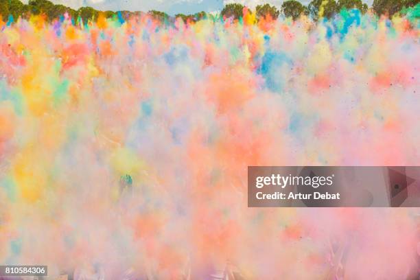 beautiful moment during holi festival celebration of people throwing colored dust on the air creating nice clouds of colors in the beginning of the party - india festival stock-fotos und bilder