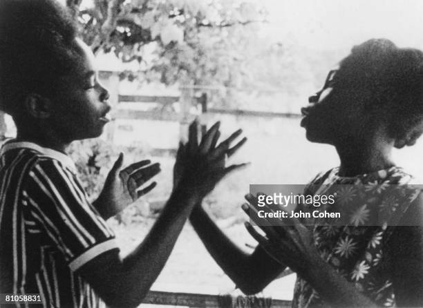 Two unidentified children slap hands as they play 'pat-a-cake,' a clapping game on Johns Island, South Carolina, 1974.