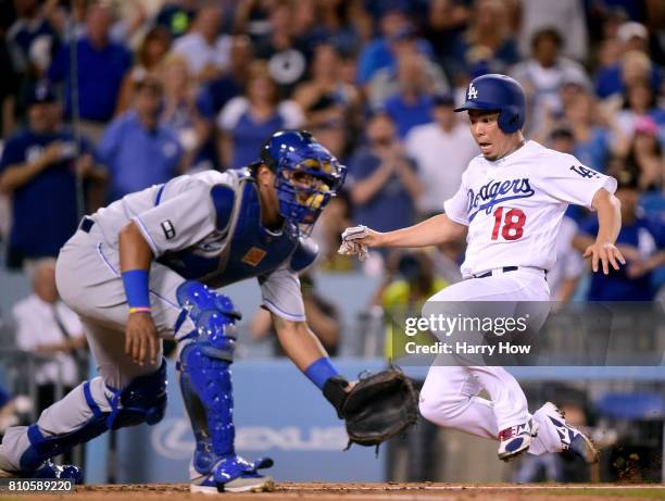 Kenta Maeda of the Los Angeles Dodgers slides to scores past Salvador Perez of the Kansas City Royals, from a Corey Seager single to take a 2-1 lead...