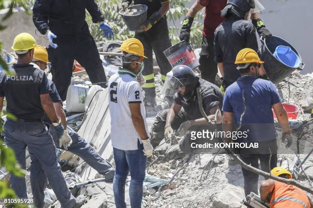 Volunteers and fire fighters work uninterruptedly to try to recover the eight dispersed under the ruins of the collapsed palace at Torre Annunziata,...