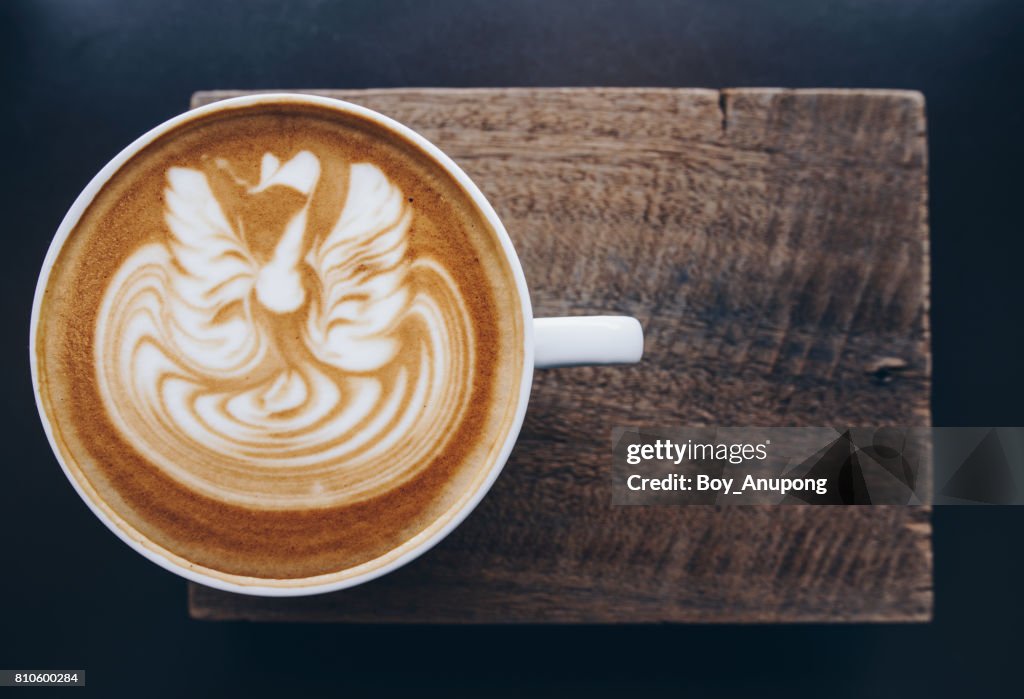 A cup of hot coffee with latte art on the surface.