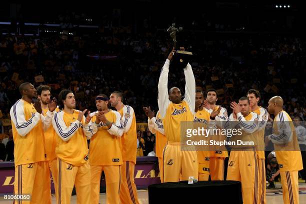 Kobe Bryant of the Los Angeles Lakers holds up the MVP Trophy as he is joined by his teammates before the start of Game Two of the Western Conference...