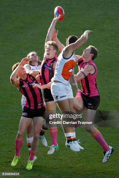 Jonathon Patton of the Giants spoils in front of James Sicily of the Hawks during the round 16 AFL match between the Hawthorn Hawks and the Greater...