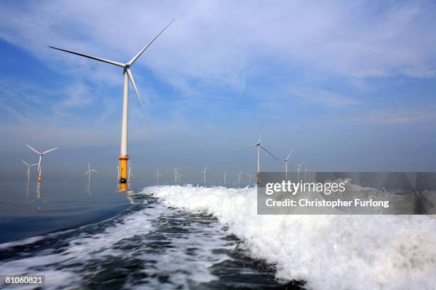 Turbines of the new Burbo Bank off shore wind farm lay in the wake of a maintenance boat in the mouth of the River Mersey on May 12, 2008 in...