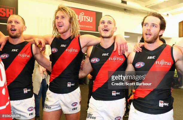 James Kelly of the Bombers, Dyson Heppell of the Bombers and David Zaharakis of the Bombers sing the song in the rooms after winning the round 16 AFL...
