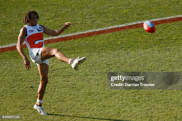 Tendi Mzungu of the Giants kicks a goal during the round 16 AFL match between the Hawthorn Hawks and the Greater Western Sydney Giants at University...