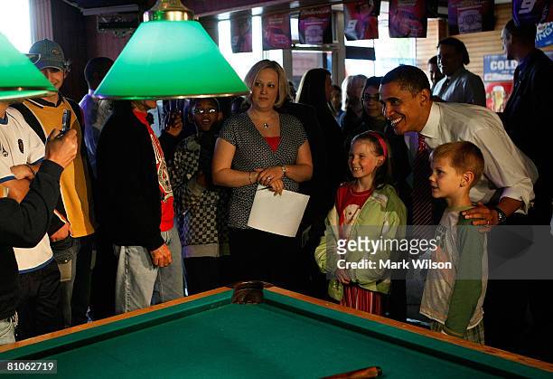 Democratic presidential hopeful Sen. Barack Obama poses for photos with people after playing a game of pool during a stop at Schultzie's Bar & Hot...